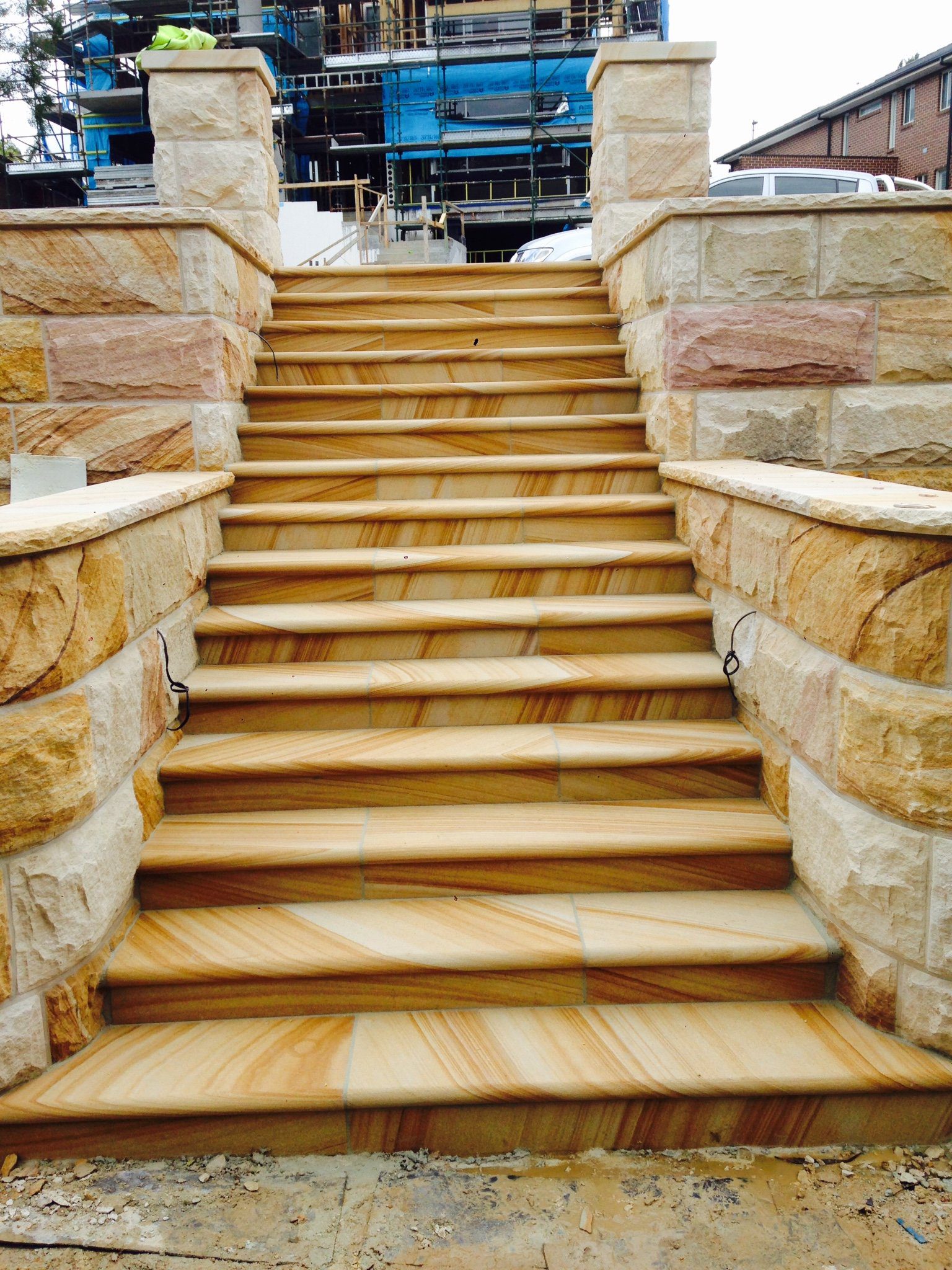 gosford-quarries-sandstone-supplies-sydney-melbourne-brisbane-Elite Stonemasons-Kellyville-project-medium-brown-bullnosed-steps-with-brown-range-curved-rockfaced-walling