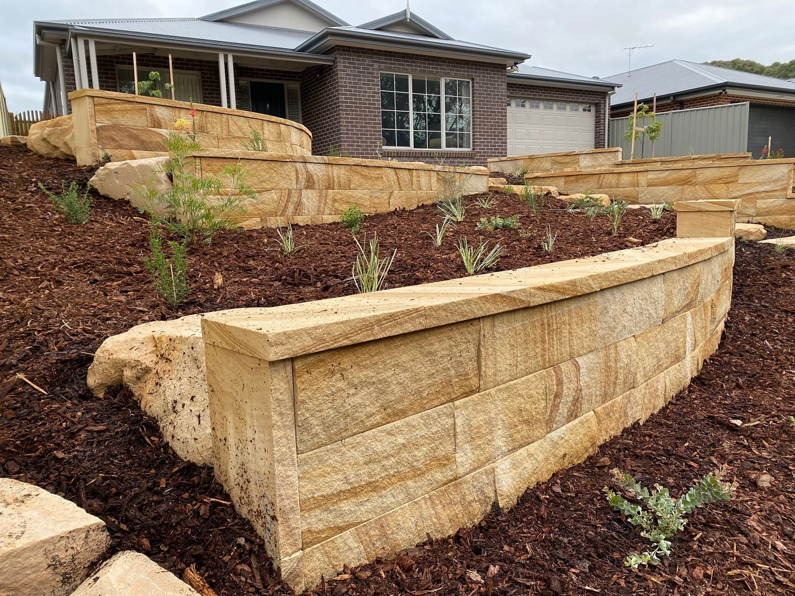 gosford-quarries-sandstone-sydney-melbourne-brisbane-residential-project-medium-brown-hydrasplit-retaining-wall-organic-steppers-landscaping-sm